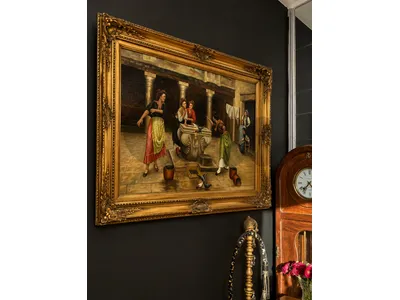 This oil painting, framed in an ornate gold style, resembles genre scenes of Italian village life popular in the late 19th century.