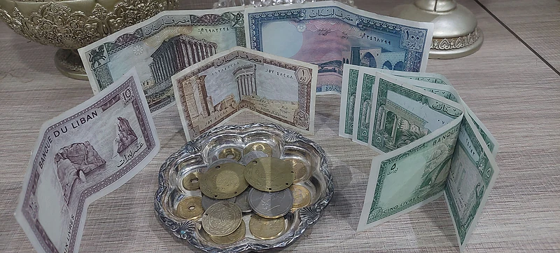 مجموعة عملات ورقية ومعدنية قديمة وتذكارات تراثية مع طبق أنتيك