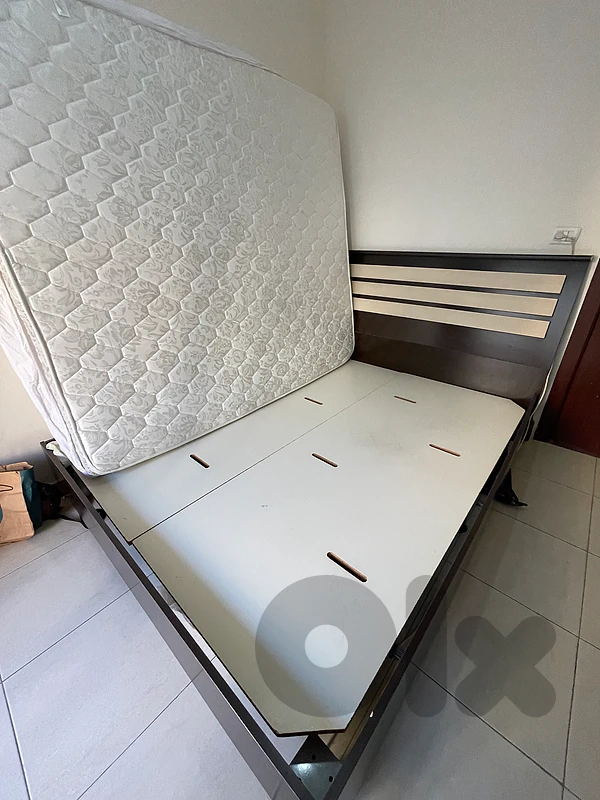 bed with mattress and a small dresser