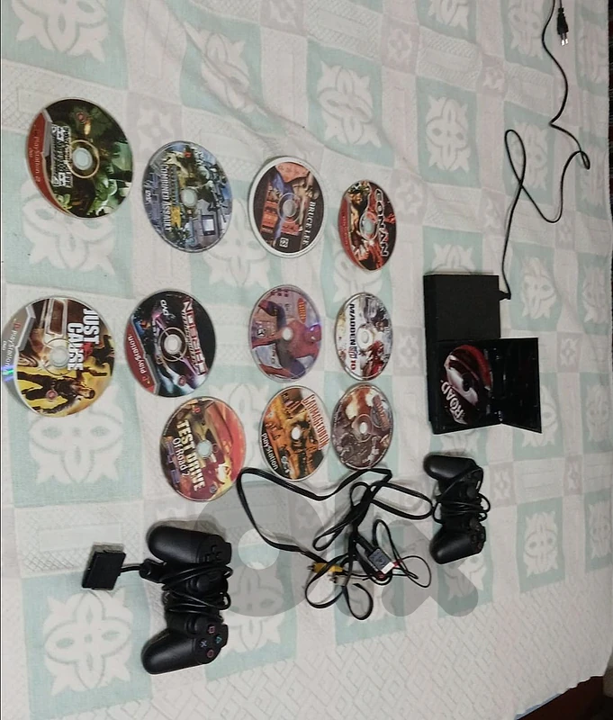 PS2 gaming console with two controllers and 12 discs.