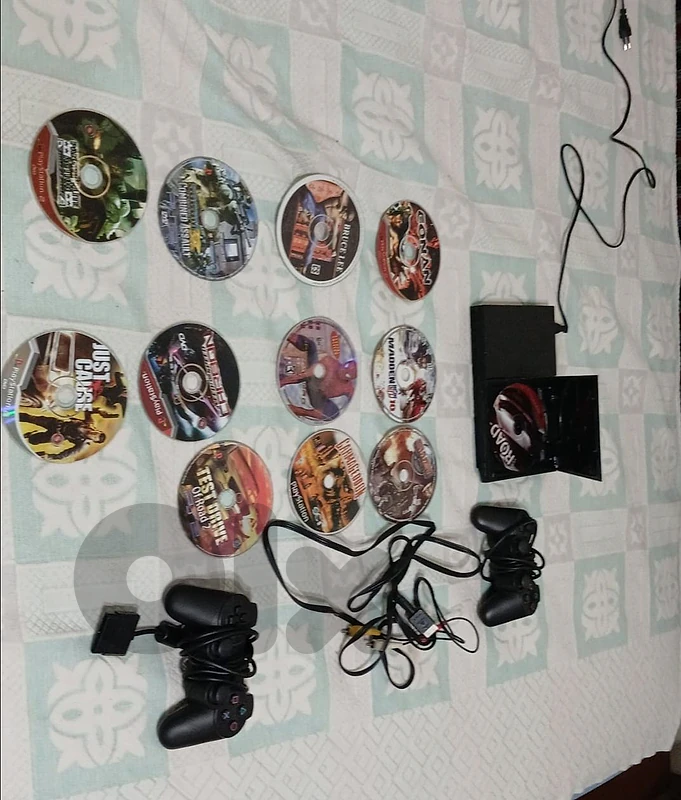 PS2 gaming console with two controllers and 12 discs.