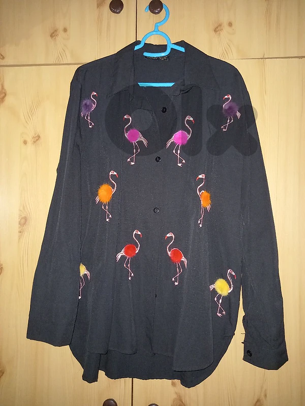 Black button-down shirt with colorful flamingo prints and pom-poms.