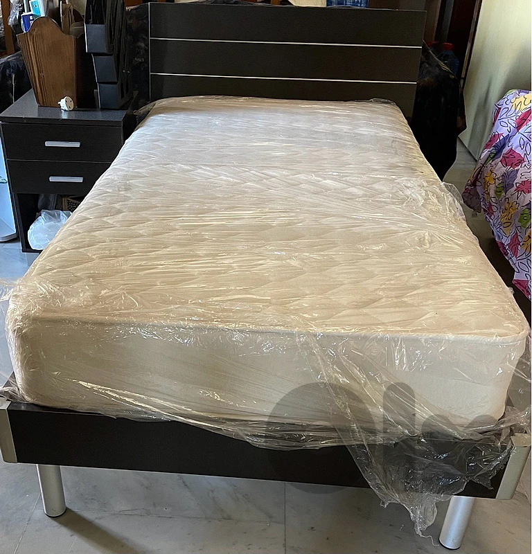 Bed with mattress and a side table