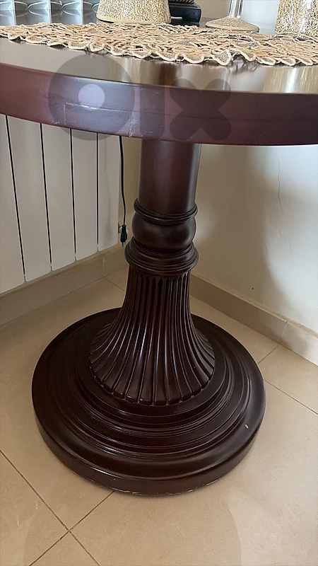 round carved wooden table in the Louis XVI style
