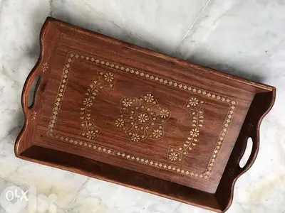 Wooden Tray with brass design pieces on it