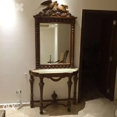 Une console surmontée d'une sculpture de deux oiseaux aimants, avec un